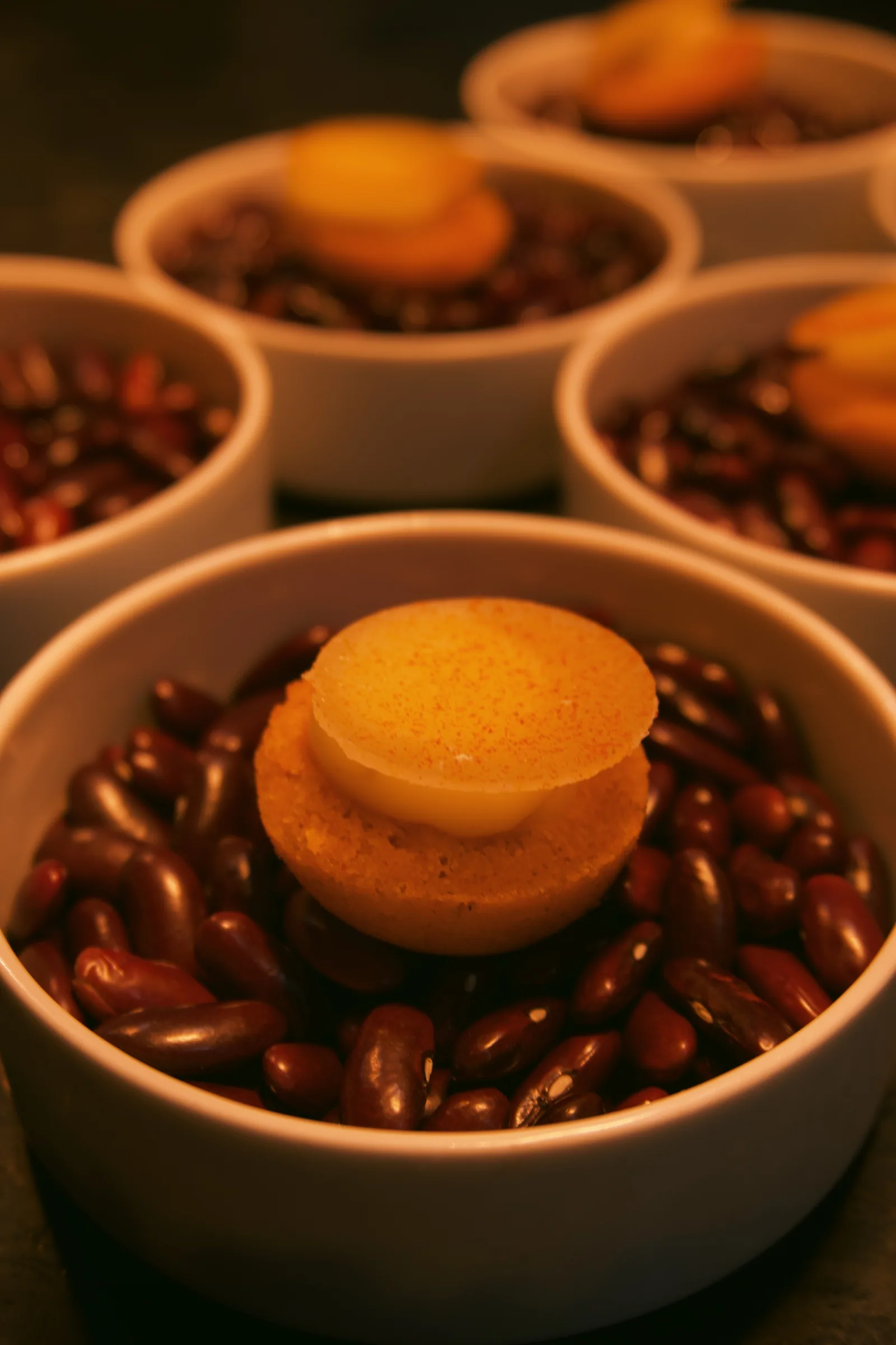 Small round bites presented in bowls filled with dried beans