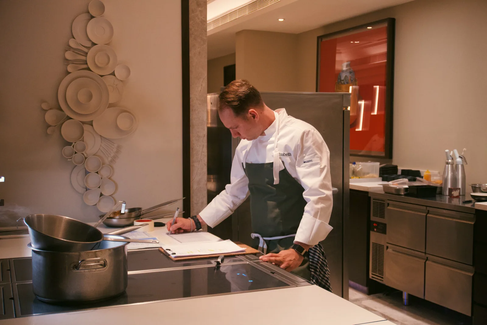 Jason reviewing handwritten notes at a kitchen counter in Hyderabad