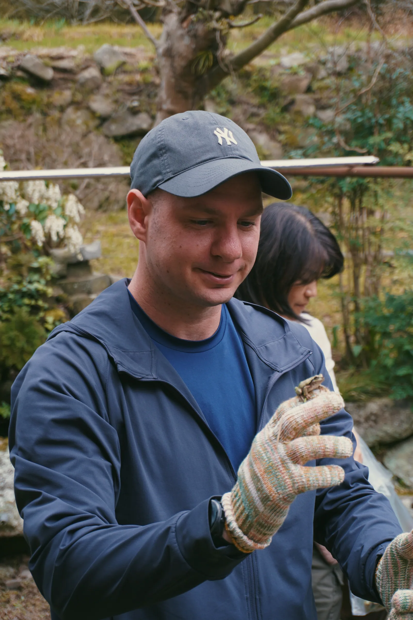 Jason wearing gloves and examining a plant while foraging in Japan