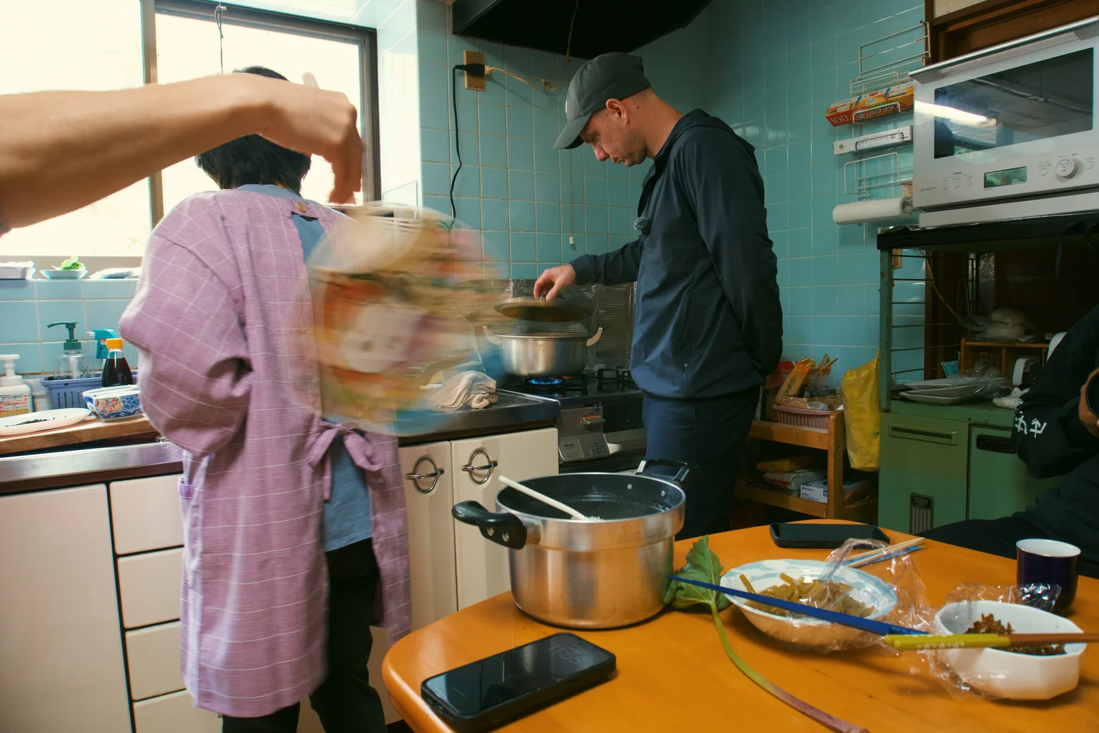 Jason cooking alongside a woman in a small Japanese kitchen