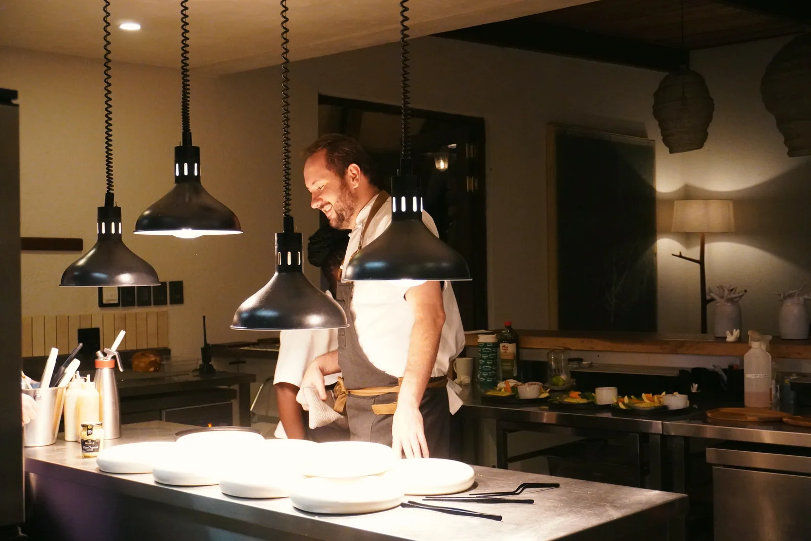 Jason at the kitchen pass under pendant lights at Few & Far Luvhondo